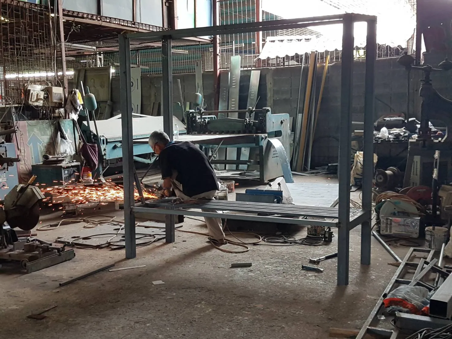 EXCESS fabricator welding a steel sign frame in the workshop