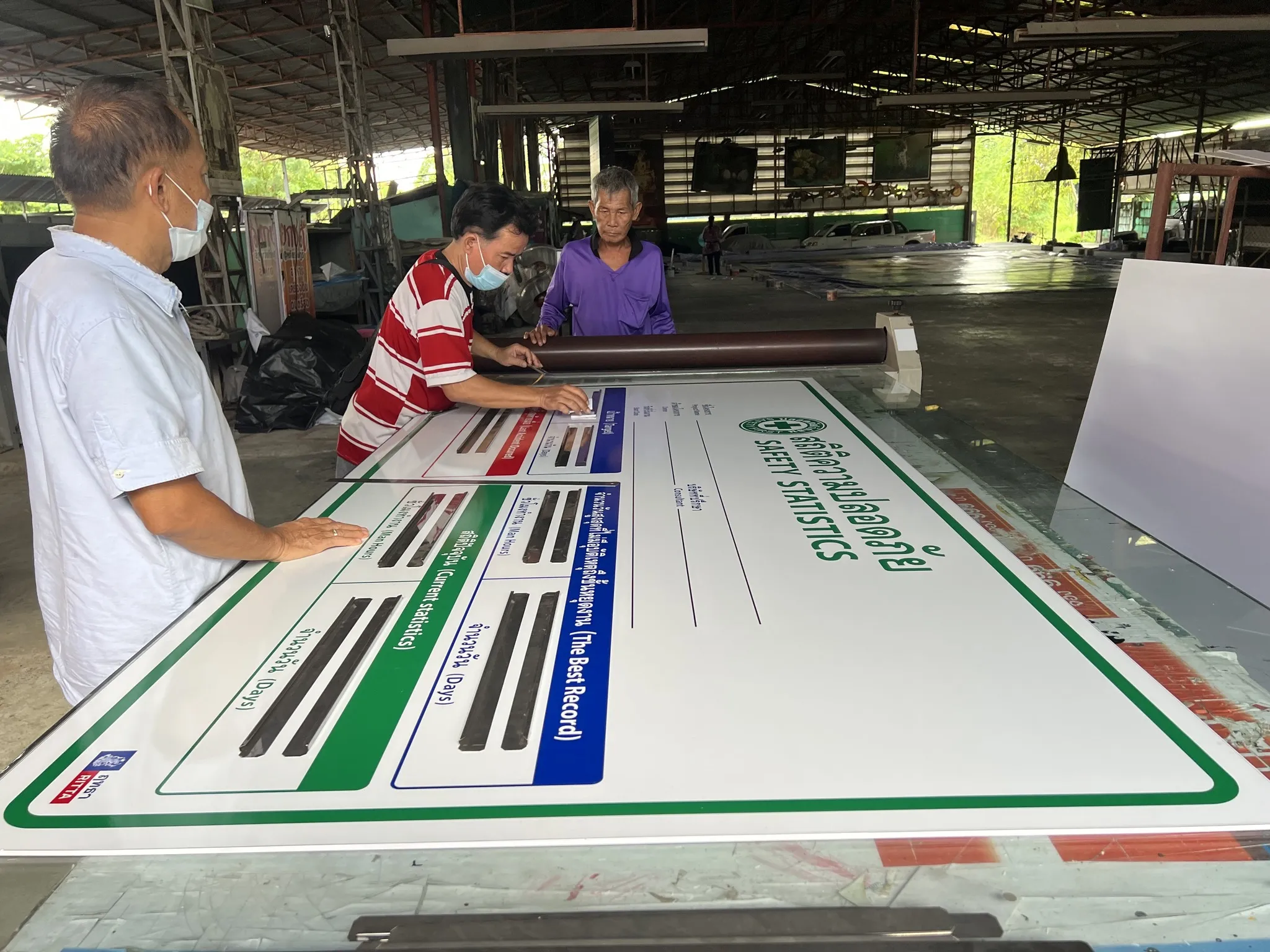 EXCESS team inspecting printed information panels in the workshop