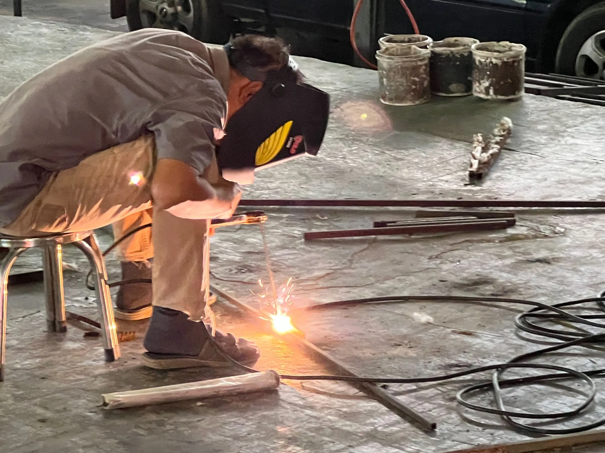 EXCESS fabricator welding a steel sign structure