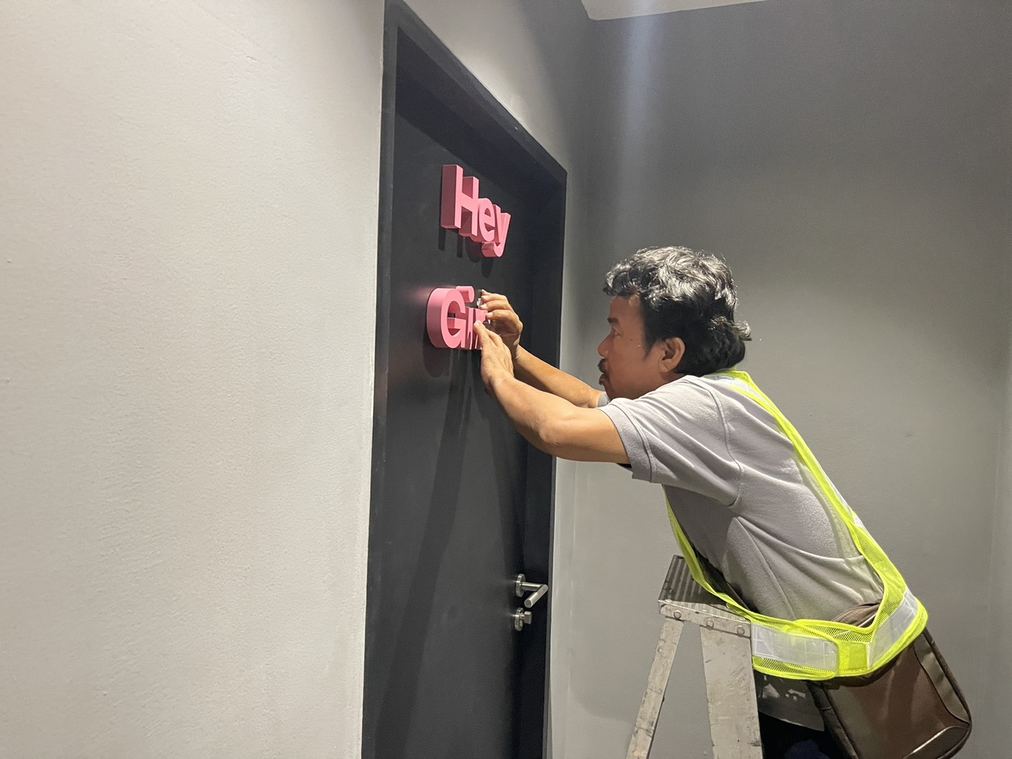 EXCESS installer aligning dimensional letters on site